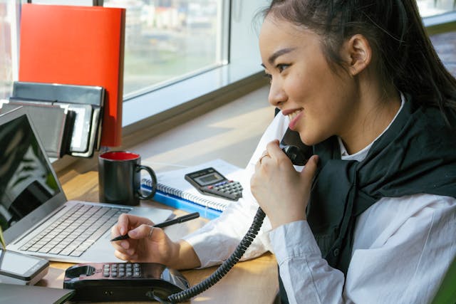 a woman on a landline at a desk