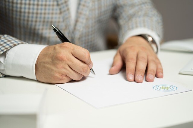 person-holding-pen-signing-a-document